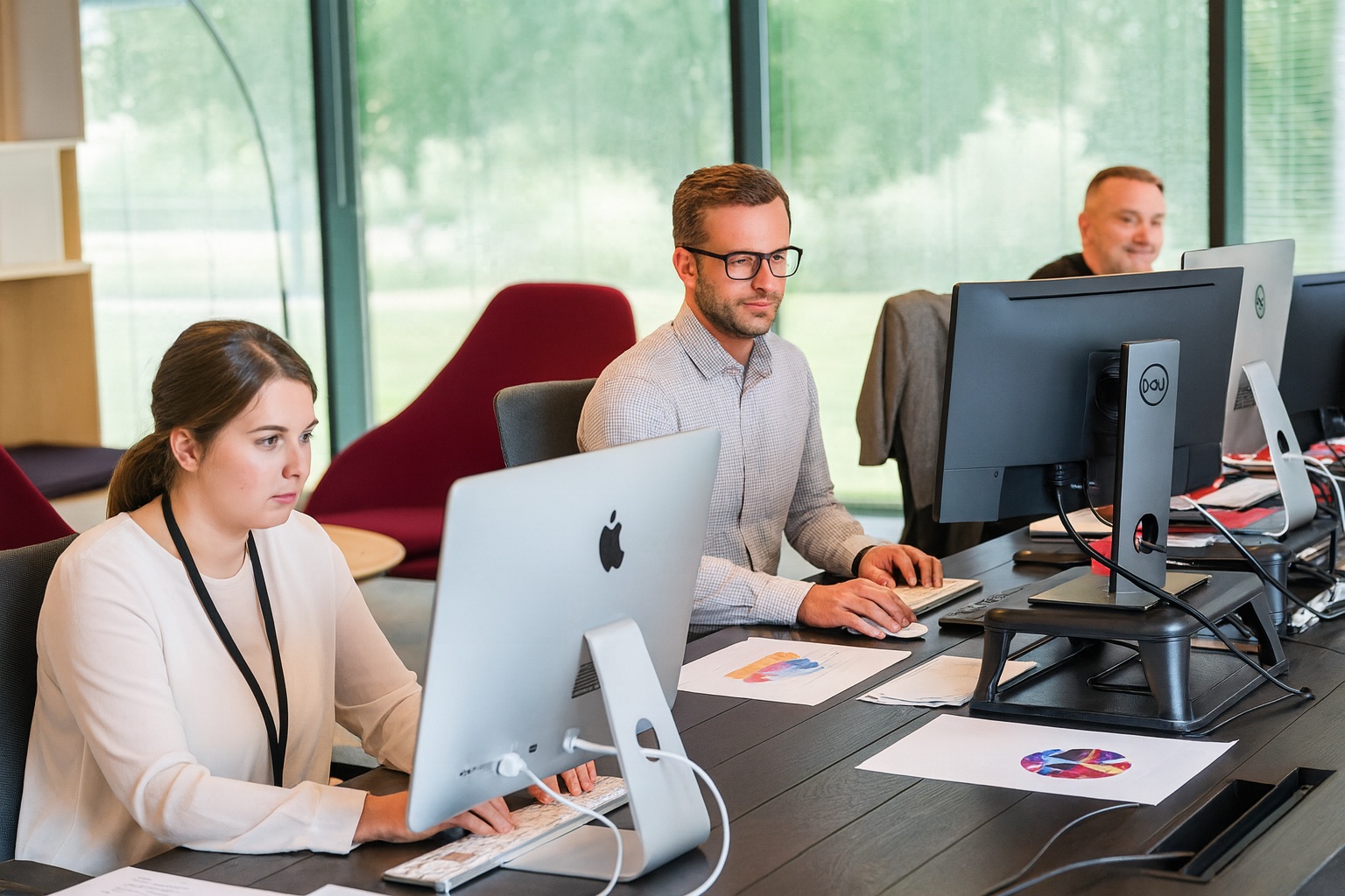 Inside our office, with Andrew and Louise working at their desks alongside colleagues